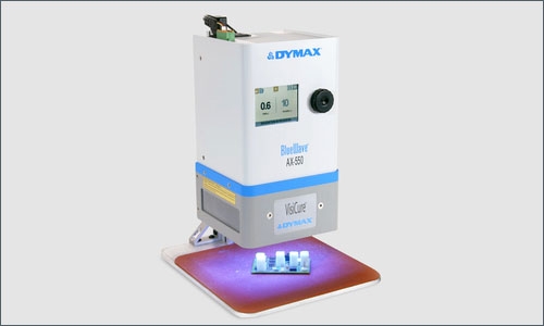 A Dymax BlueWave AX-550 flood lamp light cures an adhesive on a printed circuit board to secure components to it.